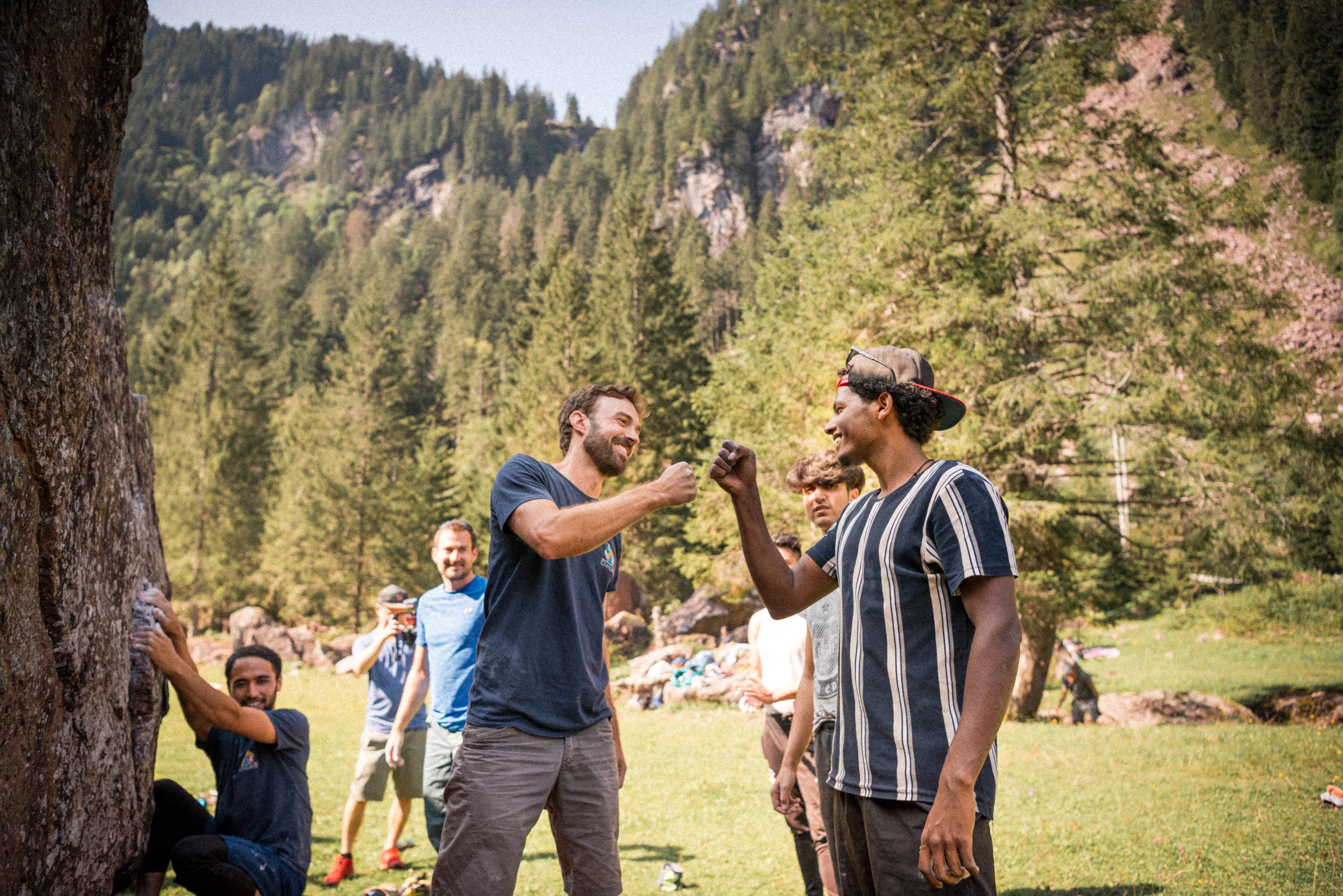 Men in front of a boulder rock wall