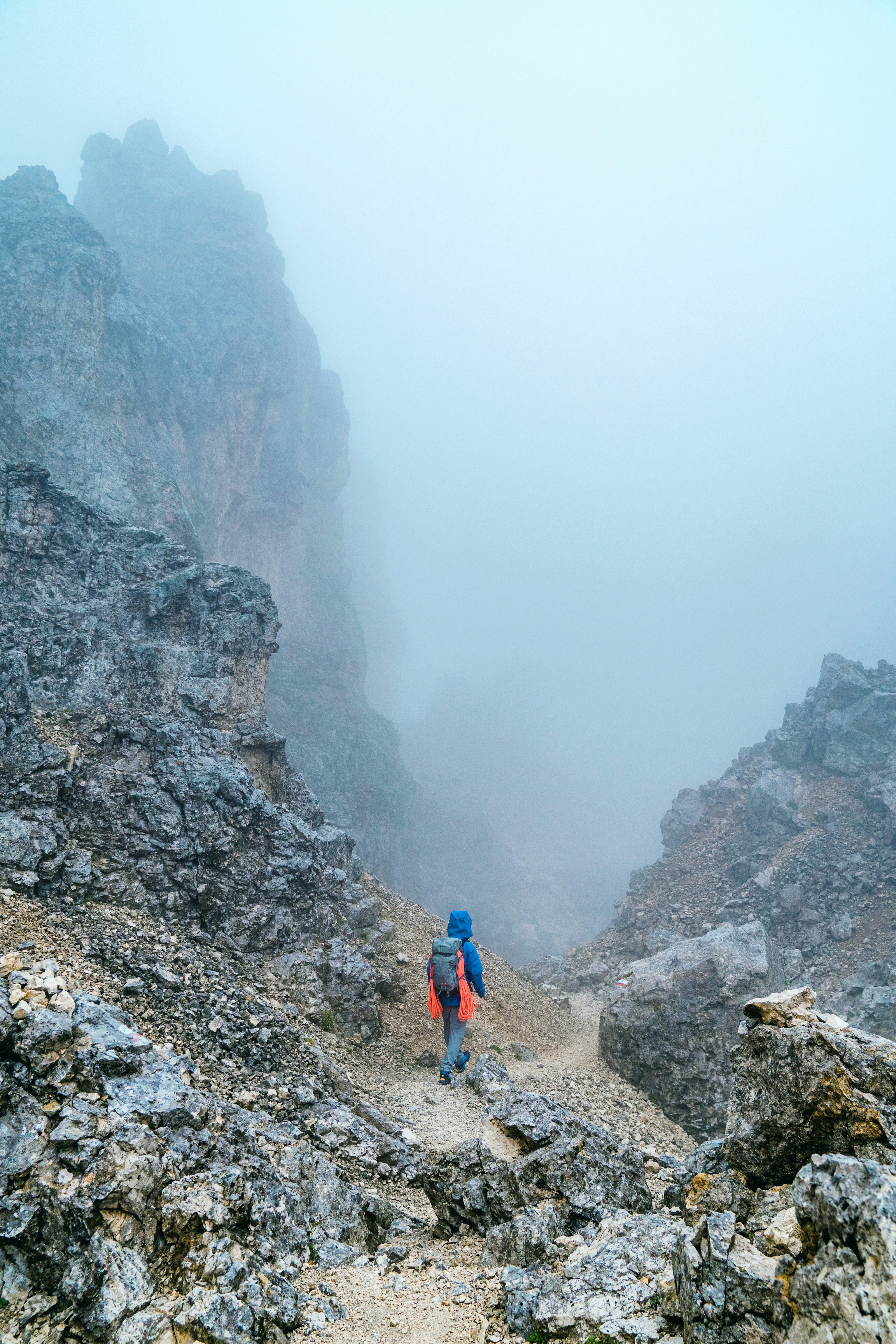 Man walking through a foggy ravine.