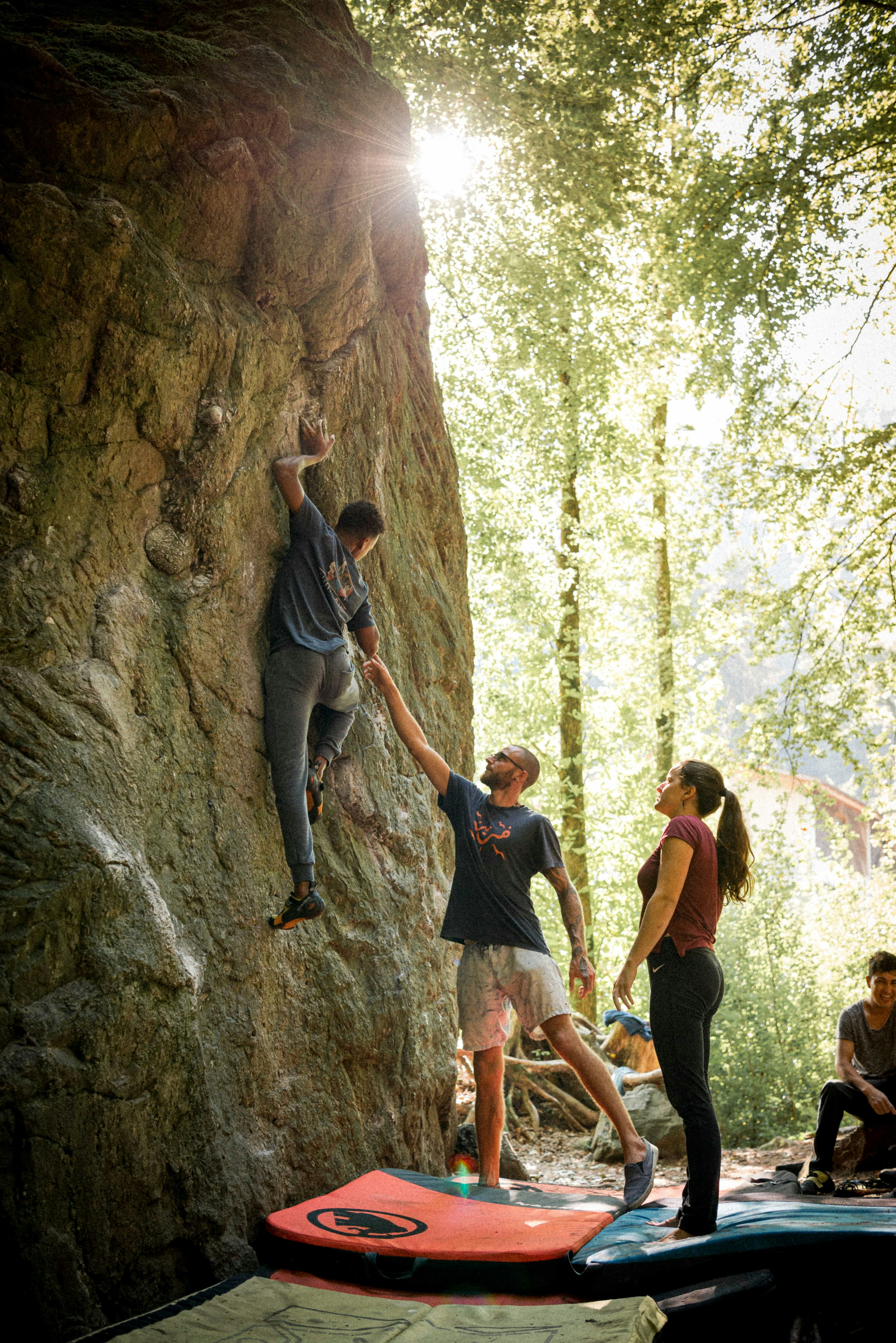 People bouldering at a rock outside in nature