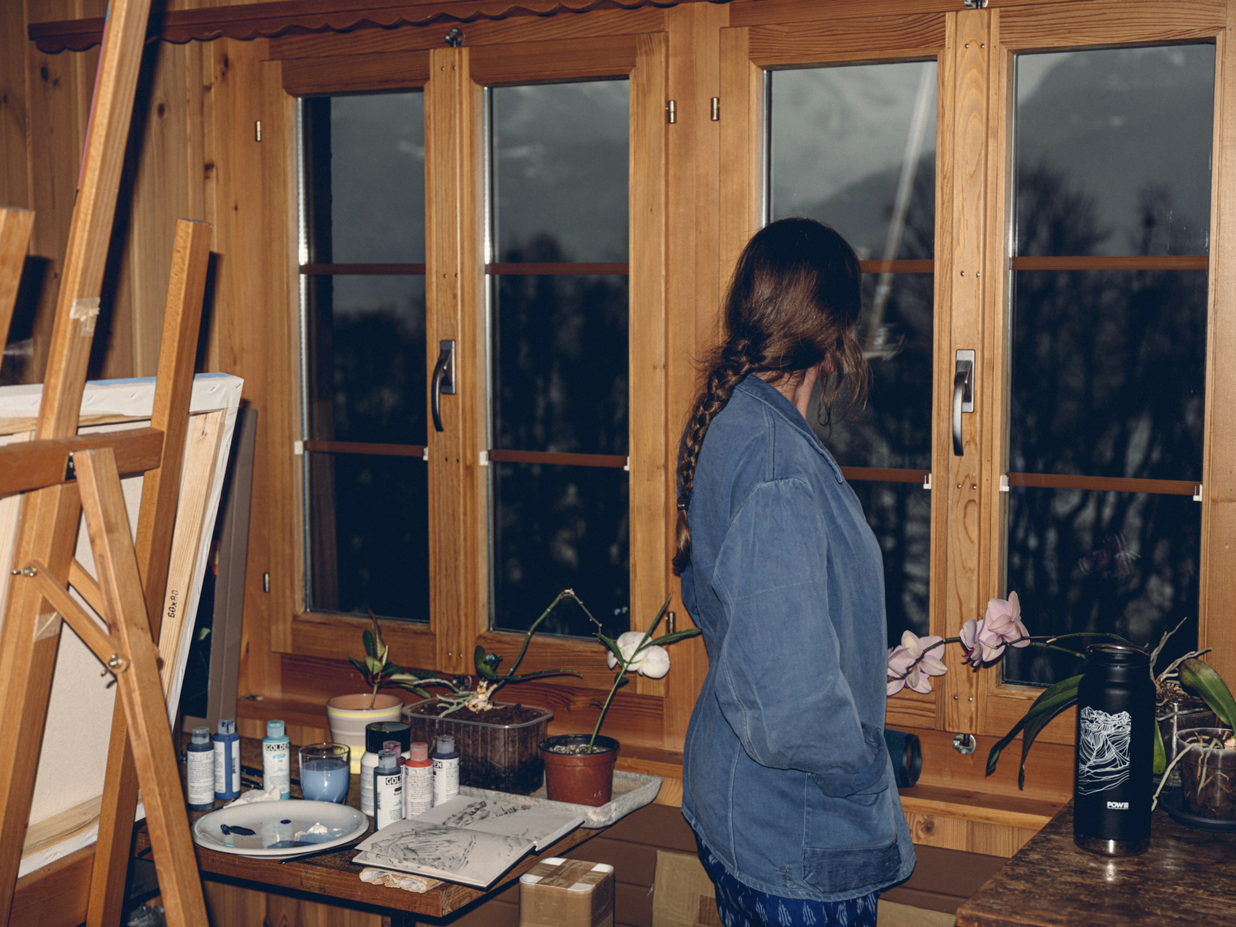 Corinne Wiedman in front of a window with painting supports.