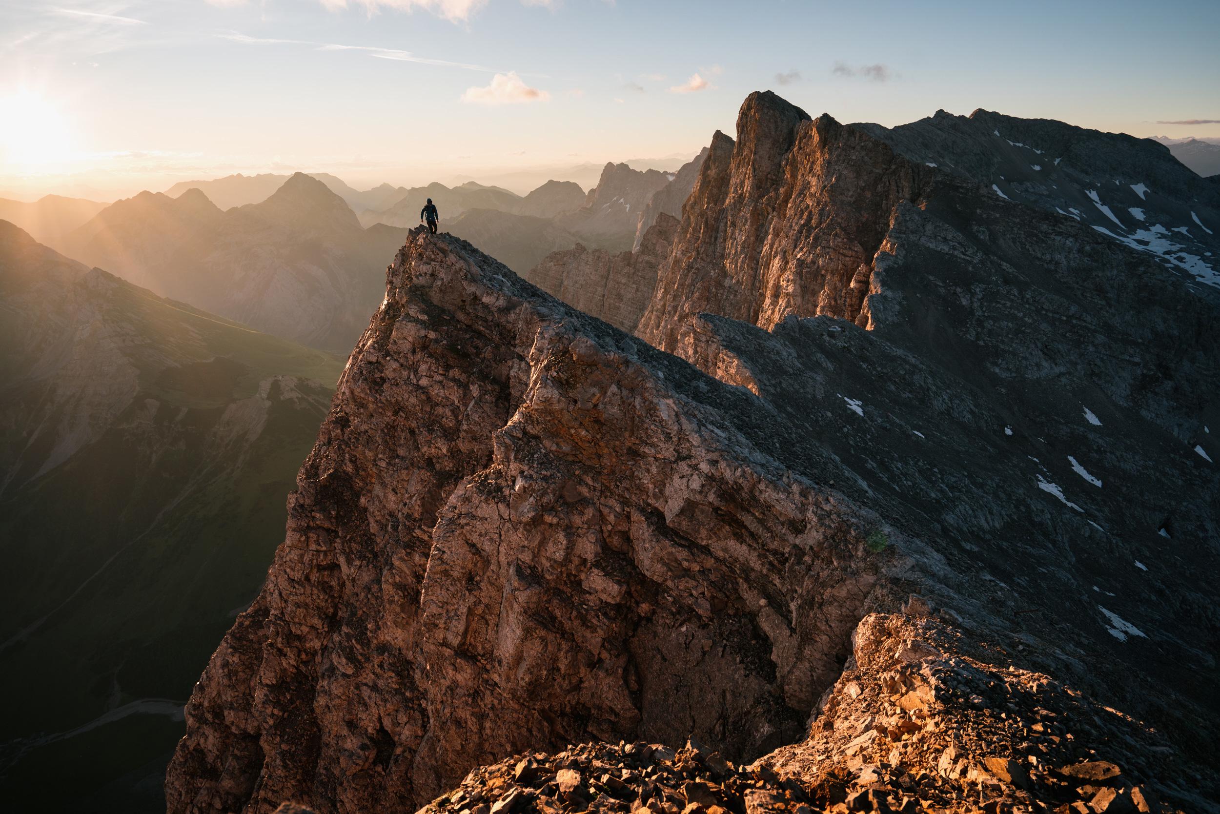 A man stands on a high peak