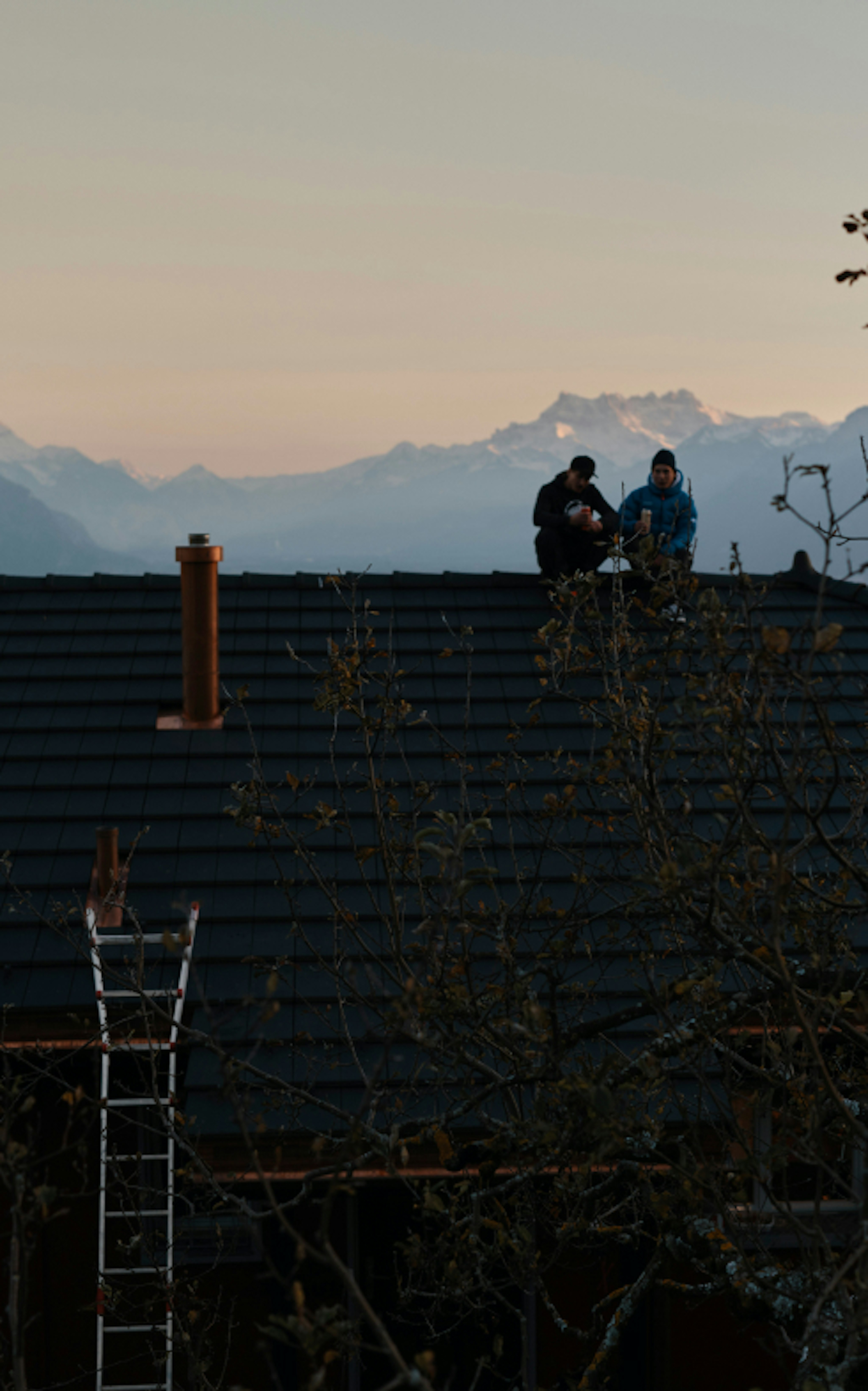 Zwei Personen sitzen auf dem Dach