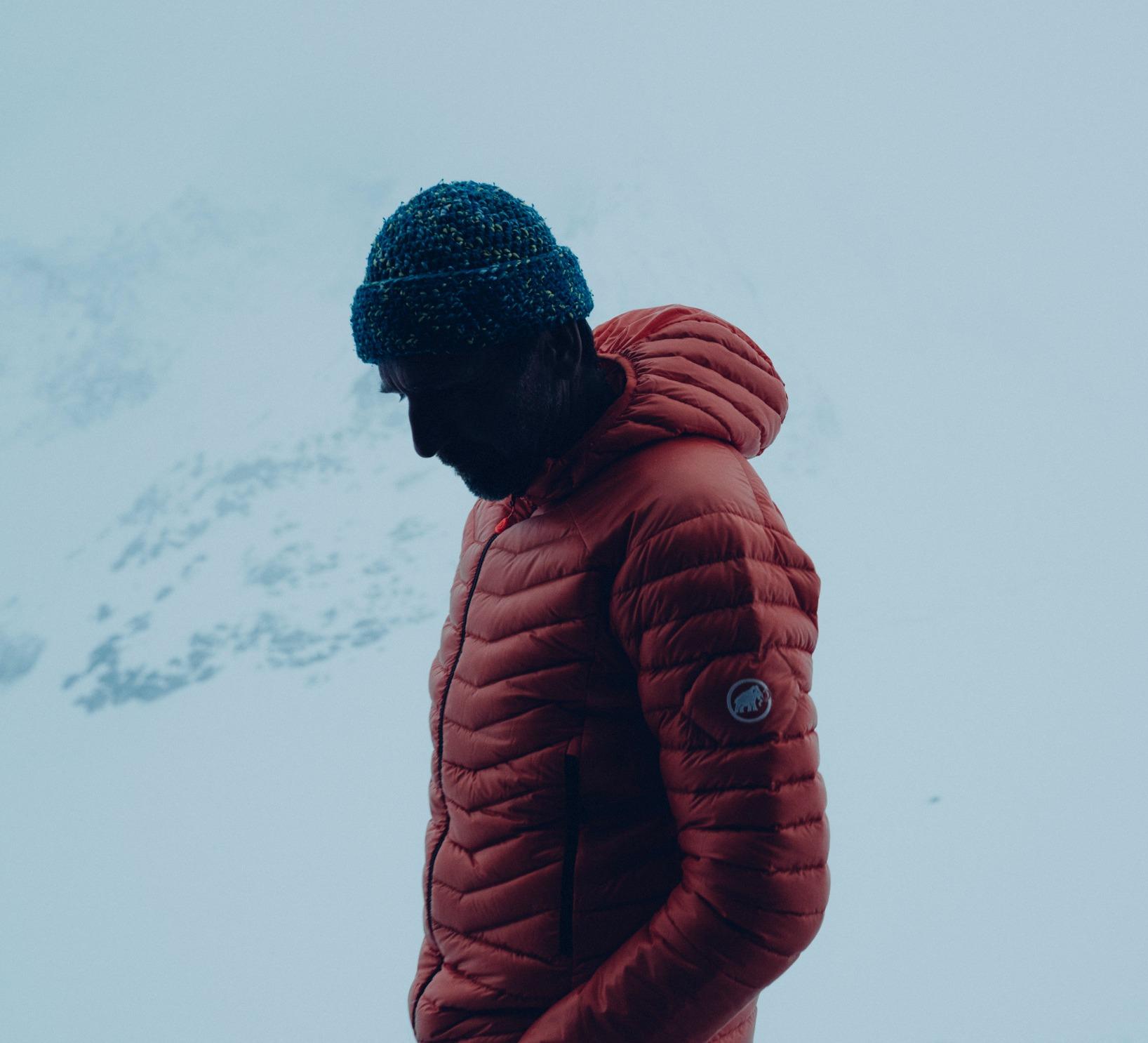 Man standing in front of snowy mountains.