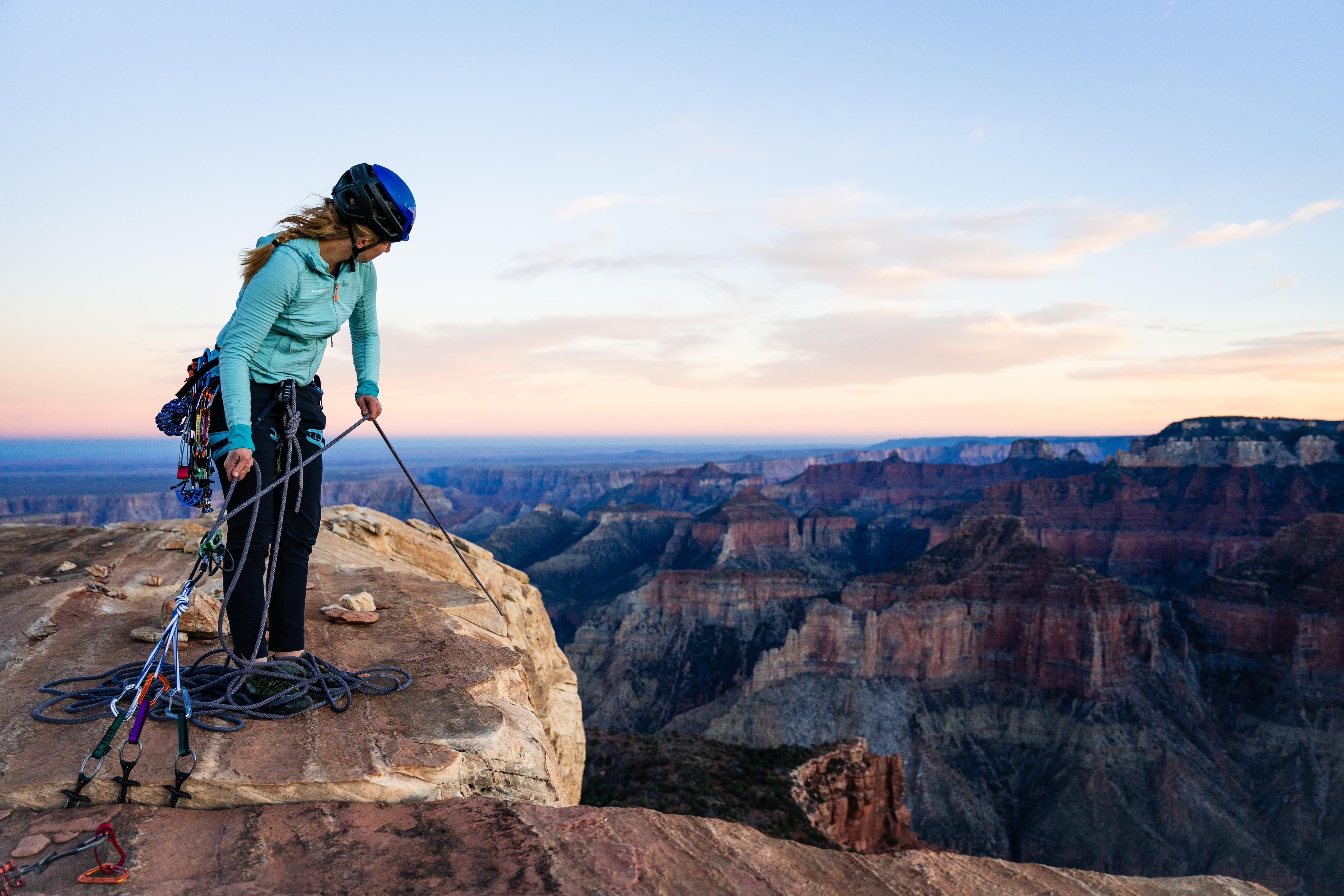 Erikka stands on a summit with Mammut equipment