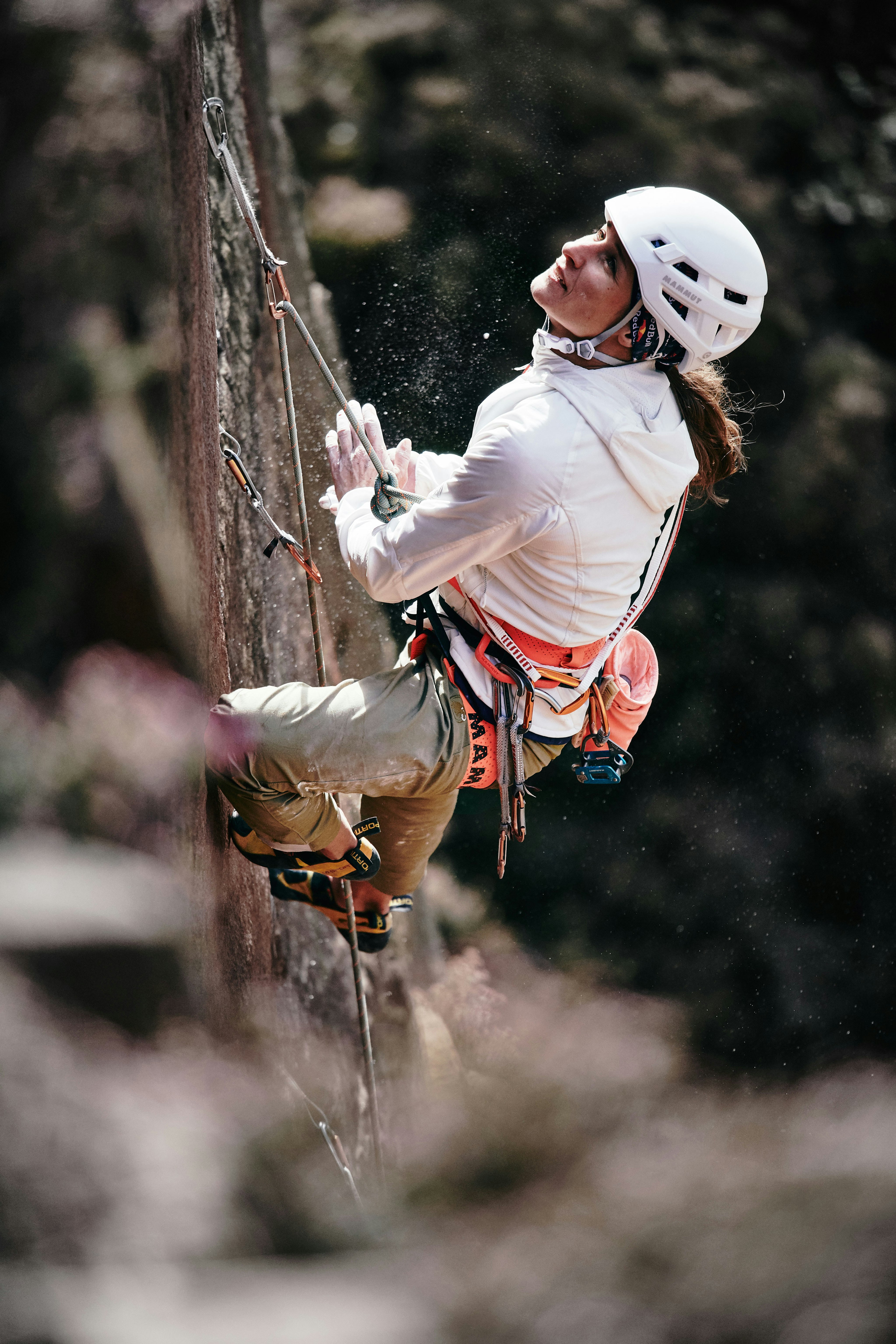 Une femme escalade une paroi rocheuse et regarde vers le haut
