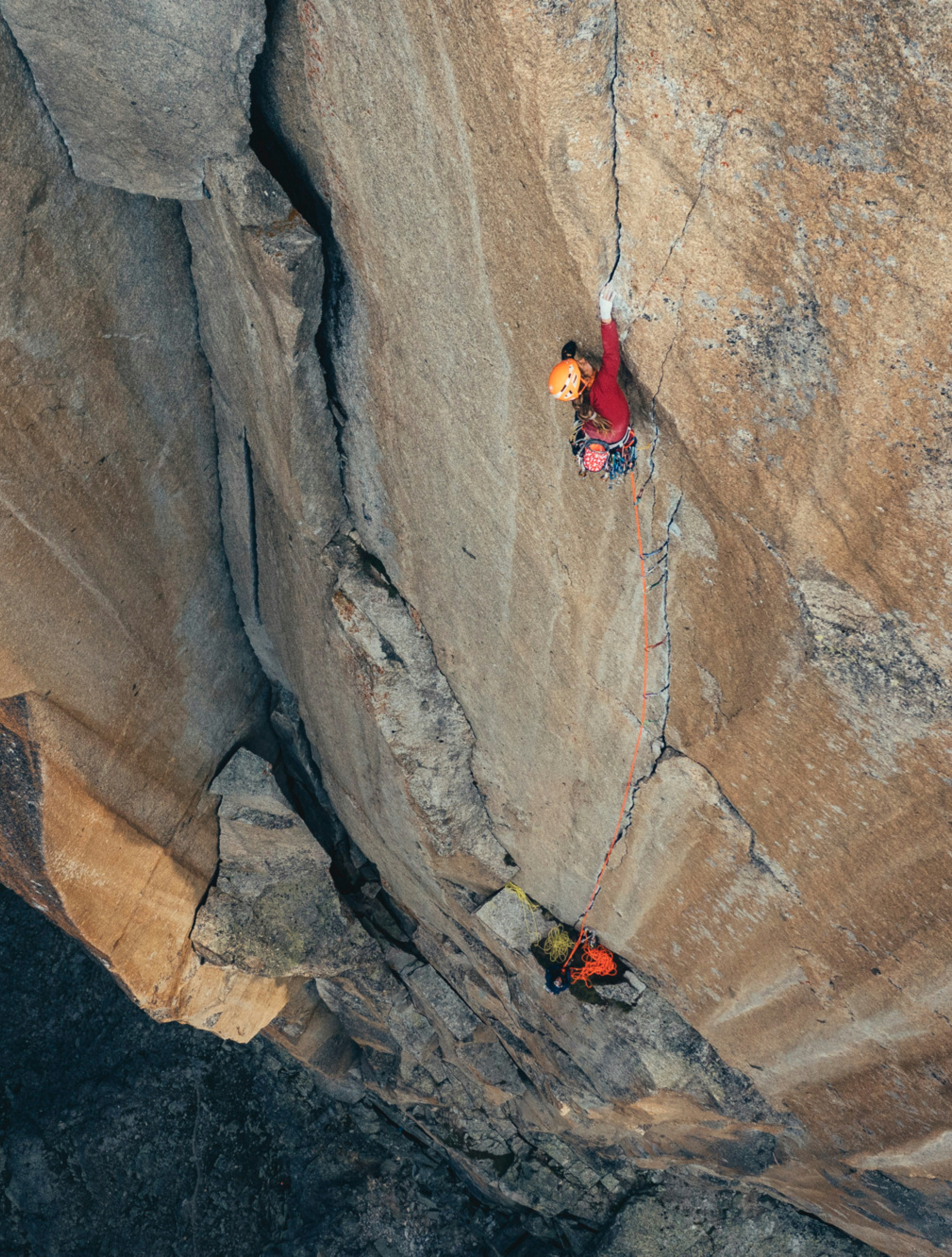 Zwei Personen klettern einen Fels hoch 