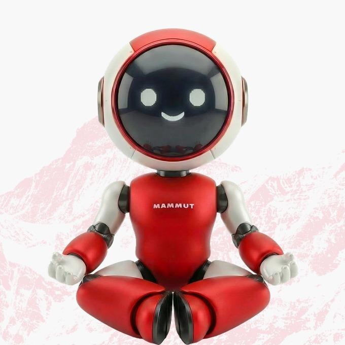 A red and white robot with a smiling face, styled like Mammut’s mascot, sits cross-legged meditating against a light background.