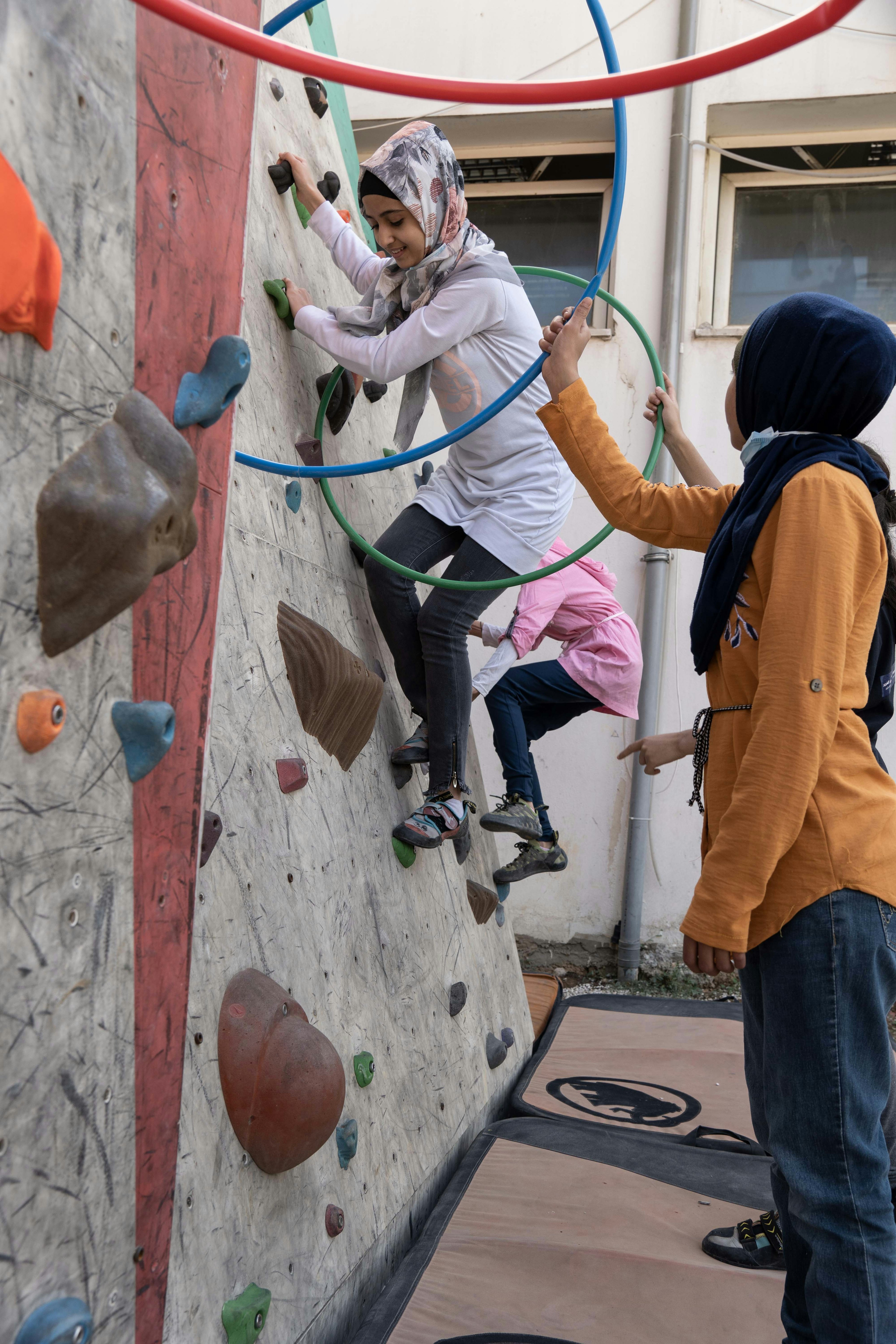 A girl bouldering on an artificial climbing wall.
