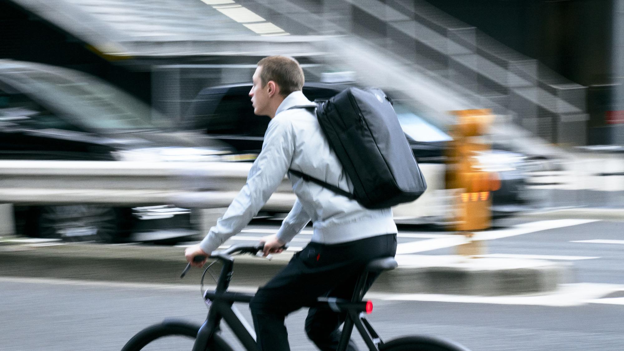 Man on bicycle with Mammut backpack