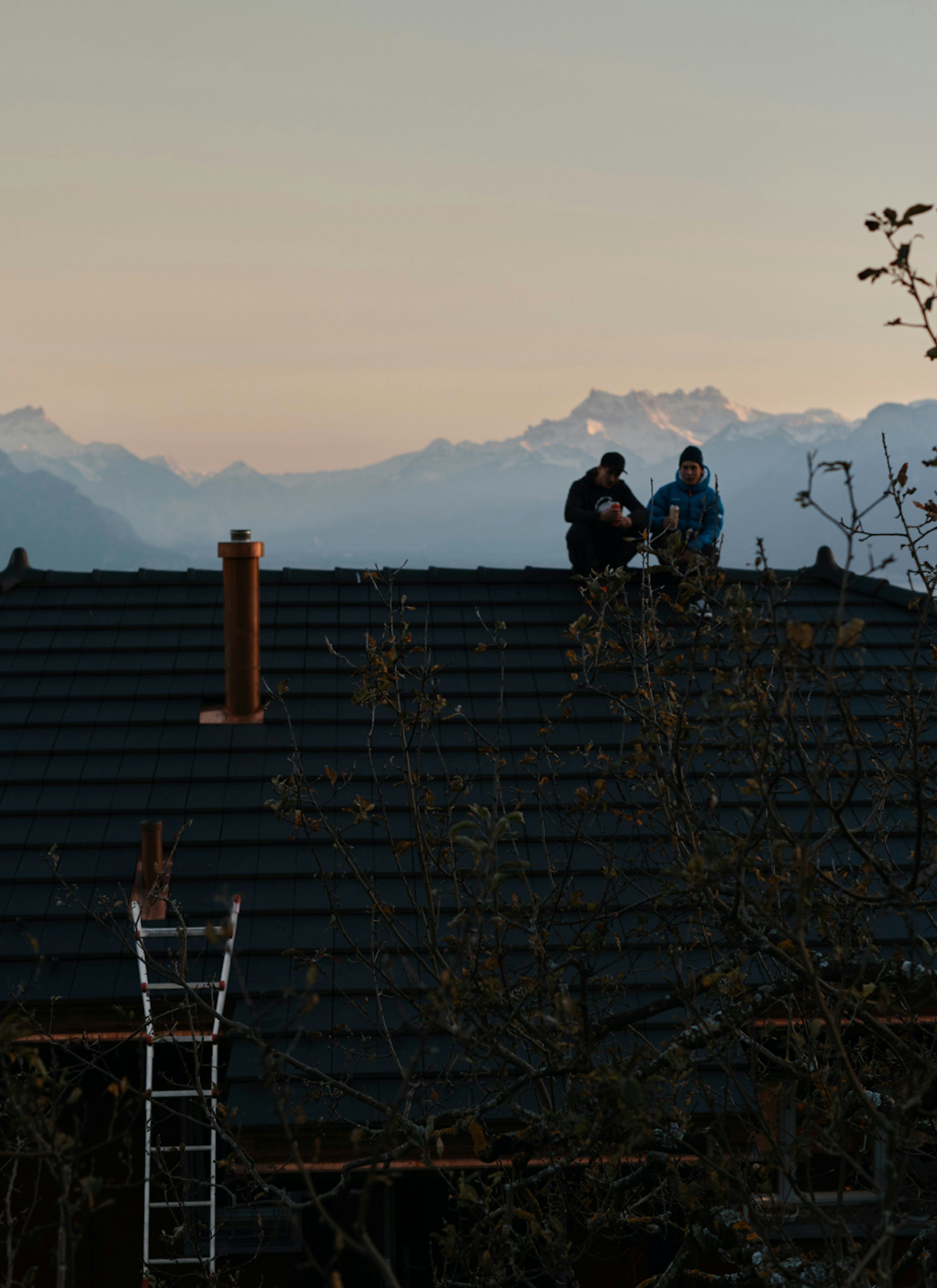 Deux hommes sont assis sur un toit. 